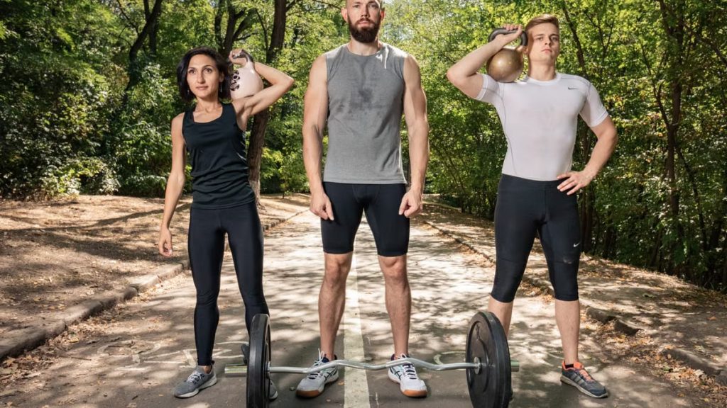 Three adults exercising outdoors with weights, promoting fitness and diversity.